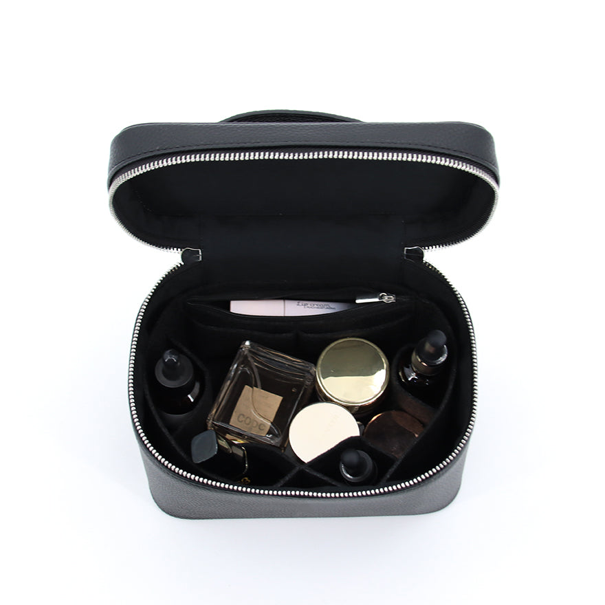 Insidan av necessär i läderlook – rymlig sminkväska med plats för flaskor och tillbehör